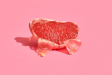 half of grapefruit citrus fruit isolated on pink
