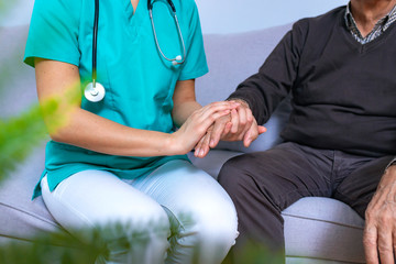 Wall Mural - Parkinson and alzheimer male senior elderly patient with caregiver in hospice care. Old man holding hand with nurse.