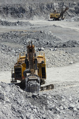 Excavator filled the ladle with rock ore in the limestone quarry.