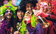canvas print picture - Lachende Freunde in bunten Kostümen trinken Sekt bei einer Karneval party .