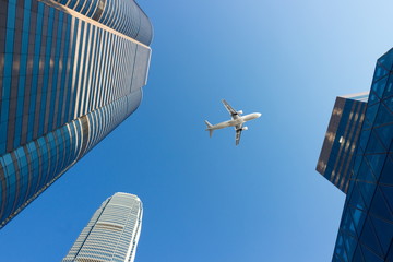 Flying aircraft above the glass skyscrapers of the business district of Hong Kong. Abstract cityscape of rapidly changing modern life. Viewed from below