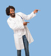 © Asier - Handsome african american medical doctor pointing to the side, smiling surprised presenting something, natural and casual