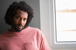 © Asier - Young african man face closeup, shocked and serious, near a window.