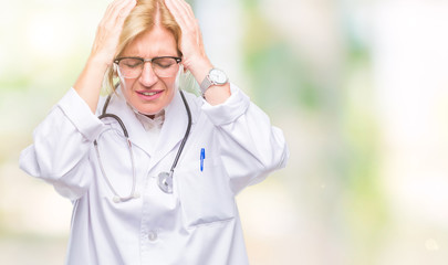 Sticker - Middle age blonde doctor woman over isolated background suffering from headache desperate and stressed because pain and migraine. Hands on head.