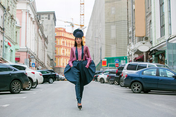 Poster - Young beautiful woman in a blue short dress walking on the road