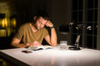 © Krakenimages.com - Young handsome man studying at home, reading a book at night