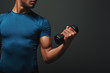 © Friends Stock - Stronger, Better, Faster. Dark skinned sportsman working out with dumbbells over dark background