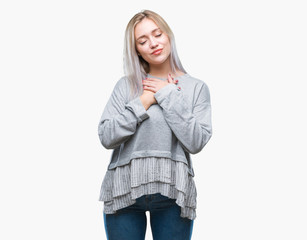 Young blonde woman over isolated background smiling with hands on chest with closed eyes and grateful gesture on face. Health concept.