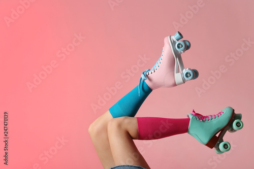 Fotografía Woman with vintage roller skates on color background, closeup