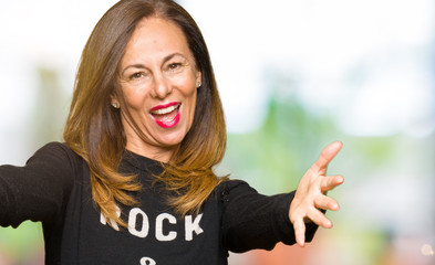 Sticker - Beautiful middle age woman wearing rock and roll sweater looking at the camera smiling with open arms for hug. Cheerful expression embracing happiness.