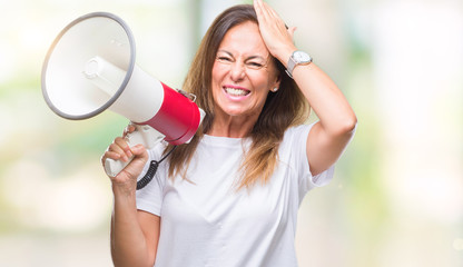 Canvas Print - Middle age hispanic woman yelling through megaphone over isolated background stressed with hand on head, shocked with shame and surprise face, angry and frustrated. Fear and upset for mistake.