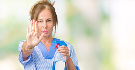  Middle age brunette cleaner woman wearing housework uniform over isolated background with open hand doing stop sign with serious and confident expression, defense gesture