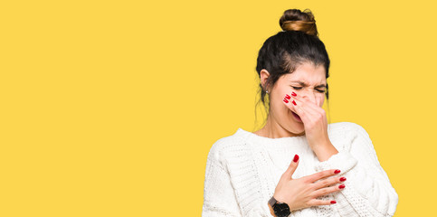 Sticker - Young beautiful woman wearing winter sweater smelling something stinky and disgusting, intolerable smell, holding breath with fingers on nose. Bad smells concept.