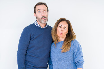 Canvas Print - Beautiful middle age couple in love over isolated background making fish face with lips, crazy and comical gesture. Funny expression.