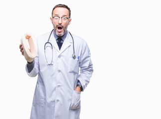 Poster - Middle age senior hoary doctor man holding neck collar over isolated background scared in shock with a surprise face, afraid and excited with fear expression