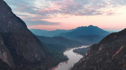 Wall Mural - Aerial: flying over Nam Ou River Nong Khiaw Muang Ngoi Laos, sunset dramatic sky, scenic mountain landscape, famous travel destination in South East Asia. Flat d-cinelike color profile.