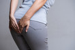 © Siam - Woman suffering from hemorrhoids and hand holding her bottom because having Abdominal pain. Health care concept.