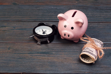 alarm clock piggy bank on old wood background