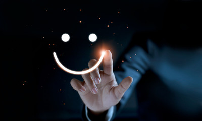 Finger of businessman touching and drawing face emoticon smile on dark background, service mind, service rating. Satisfaction and  customer service concept.