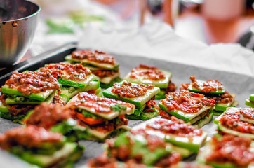 Raw vegan meal in preparation - lasagna with green zuccini , tomato and nuts