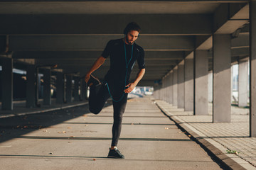 Wall Mural - Young sports man stretching outdoors