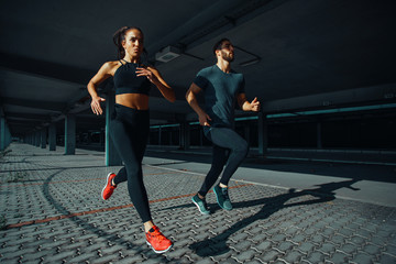 young sports couple running in the urban environment