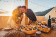 © simona - Group of friends celebrate together outdoor in the terrace with a table full of food and drinks and take selfie having fun - friendship concept for adult man and women enjoying meals celebrate summer