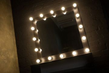 Antique mirror with lamps close up on black background