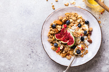 Muesli with Nuts Yogurt and fresh Figs Blueberry on the gray Background.Granola Healthy Breakfast. Sweet food Dessert. Snack  Dry Diet Nutrition Concept.Top View. Flat Lay.Copy space for Text