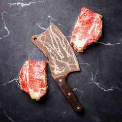 Wall Mural - Raw Fresh Marbled Meat Beef Steak and and vintage ax  on a black background.Top View Copy space for Text