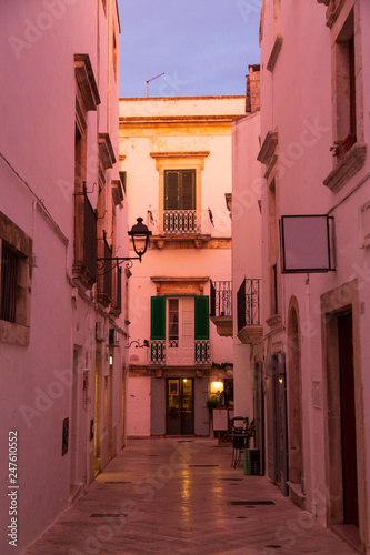 Narrow white street in Locorotondo oldtown during sunset, province Bari, Italy
