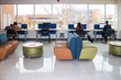 © Susan Vineyard  - Female students working at computer stations by window showing bleak winter trees and buildings in student lounge at university
