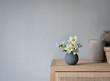 © Anna Cor - weiße Blume  in grauer Vase auf einem Schrank im skandinavischen Design