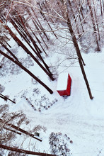 Top View Of A Red Caravan Parked Under Trees In A Snowy Winter Park