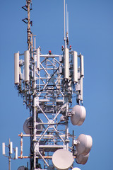 Telecommunication network repeaters, base transceiver station. Tower wireless communication antenna transmitter and repeater. Telecommunication tower with antennas. Cell phone telecommunication tower.