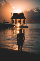 Wall Mural - Girl watching the sunset on beautiful beach in Mauritius. Trou aux Biches sunset