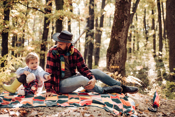 Father and son playing in the forest. Dad and son in the autumn park play laughing. Father and son playing in the autumn forest.