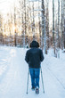 Close up photo of a man doing nordic walking in the sunlit forest on fresh powder snow, frosty weather, outdoor activities/ sunset in the background, winter sports/ healthy lifestyle and sport concept
