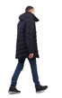 © ghoststone - side view of going  handsome man in jeans and winter jacket.