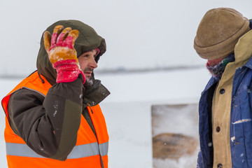 Two workers in overalls at a construction site