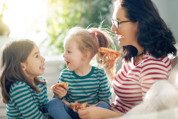 Wall Mural - Mother and daughters eating pizza