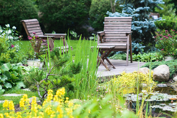 Two wooden chairs near the pond