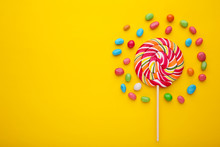 Colorful Lollipops And Different Colored Round Candy On Yellow Background