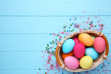 Colorful Easter Eggs In Basket On Blue Background