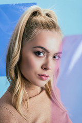 Studio shot of blonde woman with ponytail on blue background