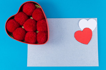 empty silver letter with two hearts of red and white color box next to balls of cotton red on a blue background Letter or invitation Minimalist concept Copy Space and template