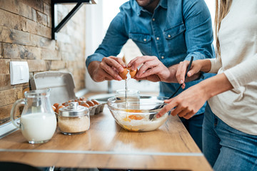 Close-up of a young couple cooking together.