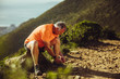 © Jacob Lund - Trail runner taking a break tying shoe lace