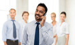 © Syda Productions - business, communication and people concept - smiling indian businessman calling on smartphone over colleagues on office background
