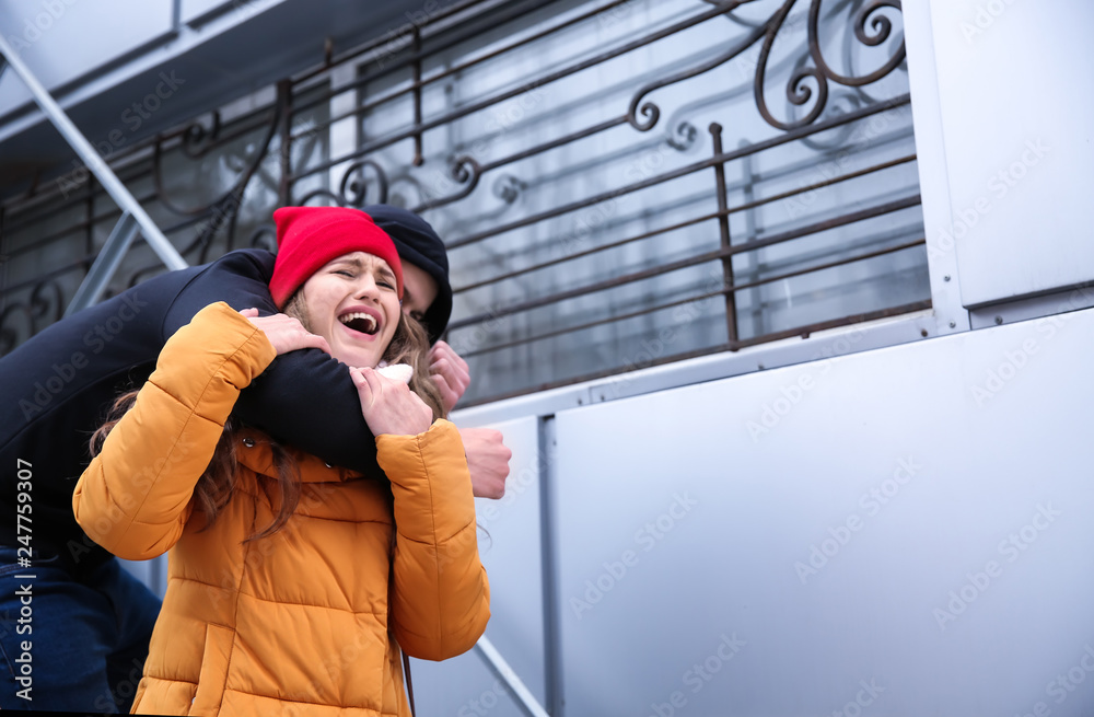 Male thief attacking young woman outdoors